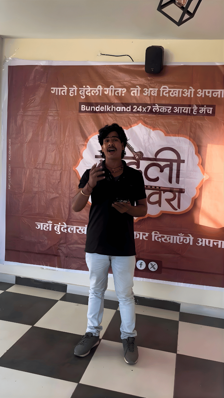 Participant presenting on stage at a Bundeli Bawra cultural event